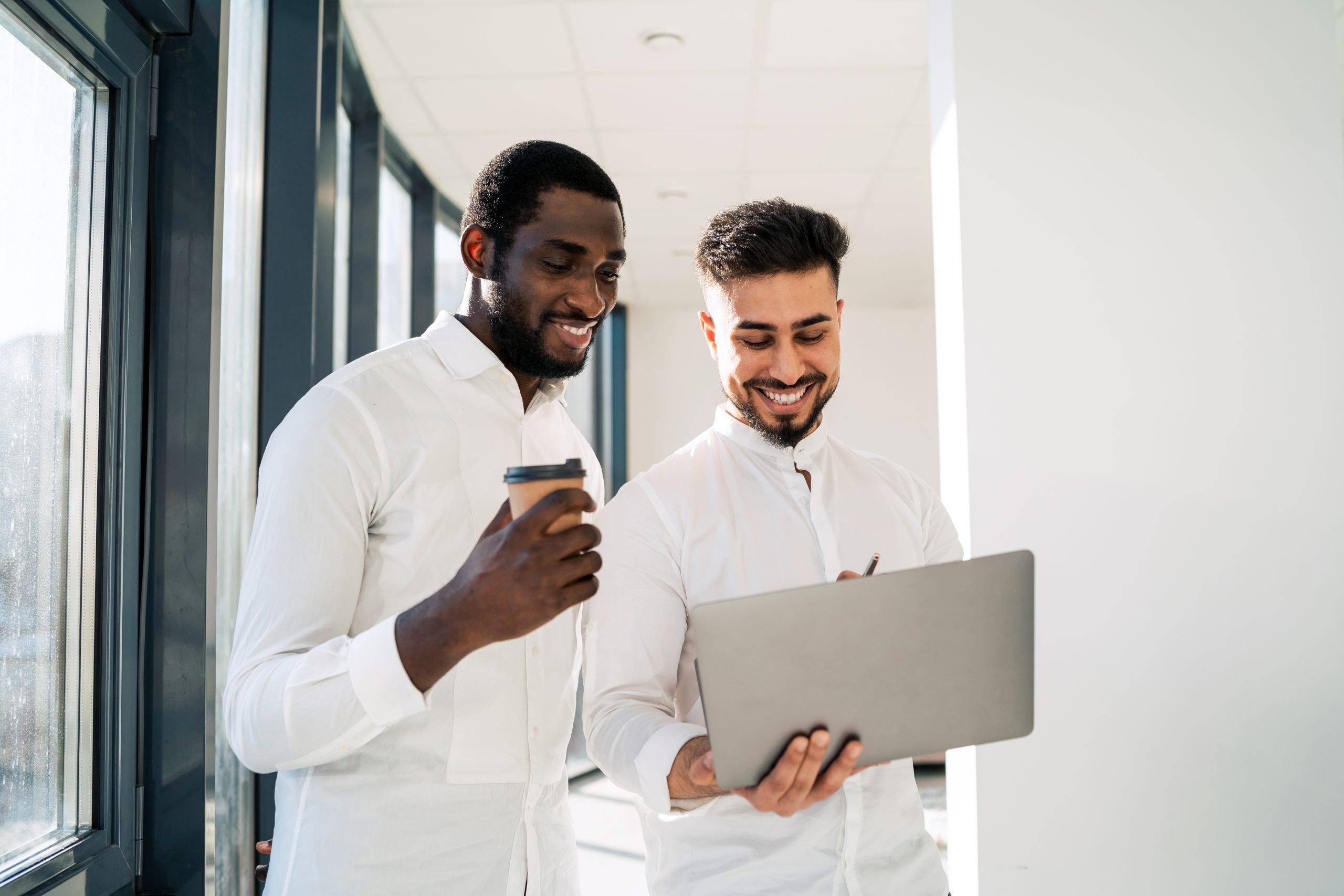 Halal Meats Sydney Quality Halal Meat Products Delivered Sydney Wide Two Multiracial Cheerful Corporate Employees Are Talking While Standing With Laptop In The Middle Of The Office